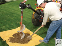 Auguring a hole in the earth for a foundation repair in 