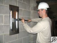 Attempting to straighten a bowed foundation wall by straightening a wall anchor system in a  home.