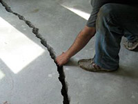 a severely damaged cracked concrete slab floor in 