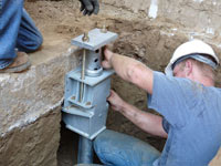 Foundation repair contractors installing the foundation bracket in Kauai.