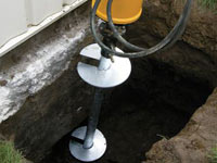 Installing a helical pier system in the earth around a foundation in Oahu