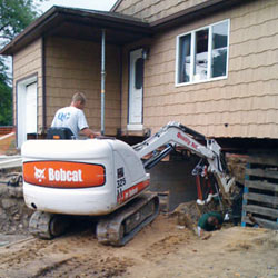 Excavating to expose the foundation walls and footings for a replacement job in 
